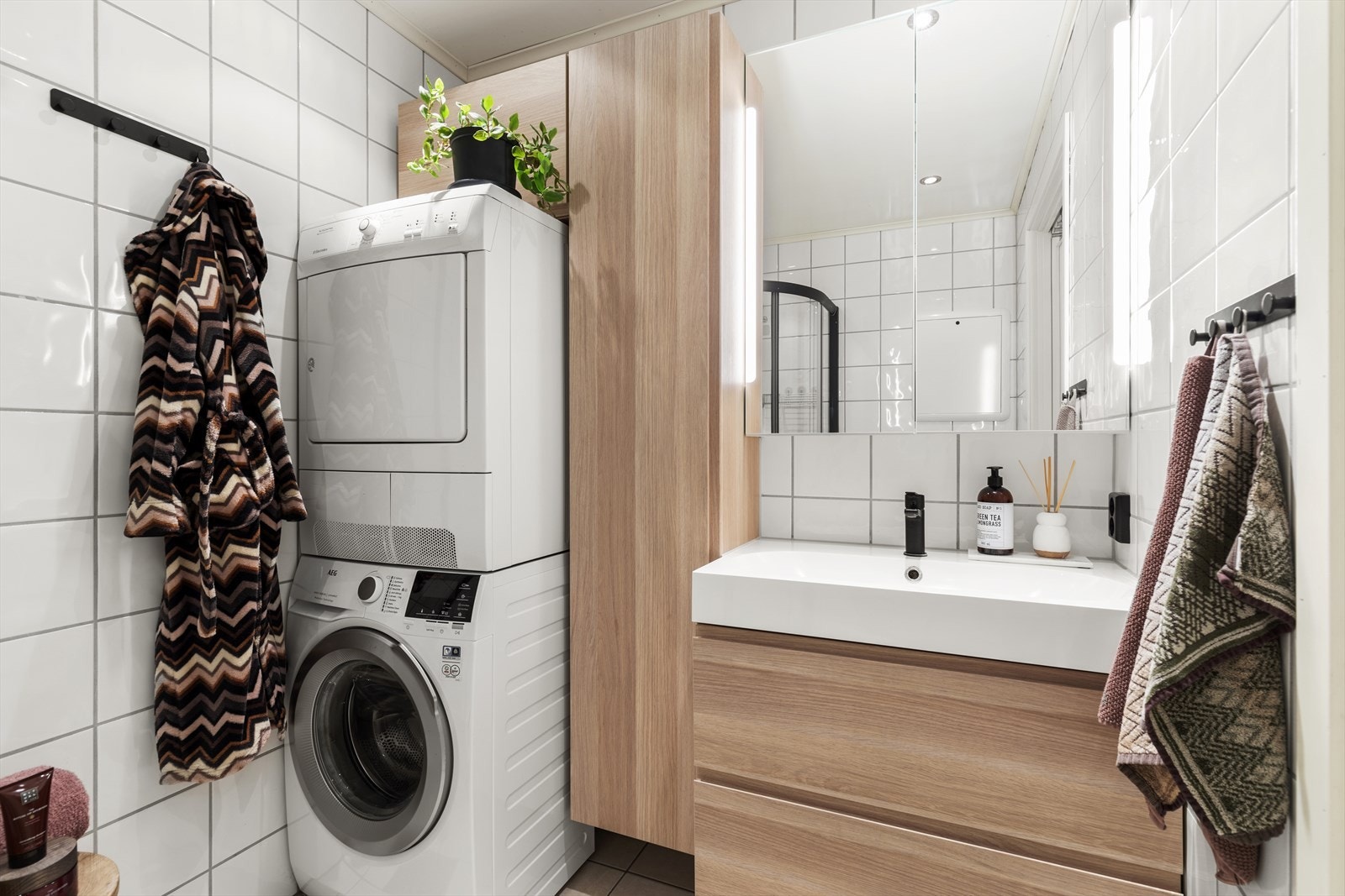 Innredning med slette fronter og heldekkende servant med opplegg for vaskemaskin og tørketrommel. Galleribilde