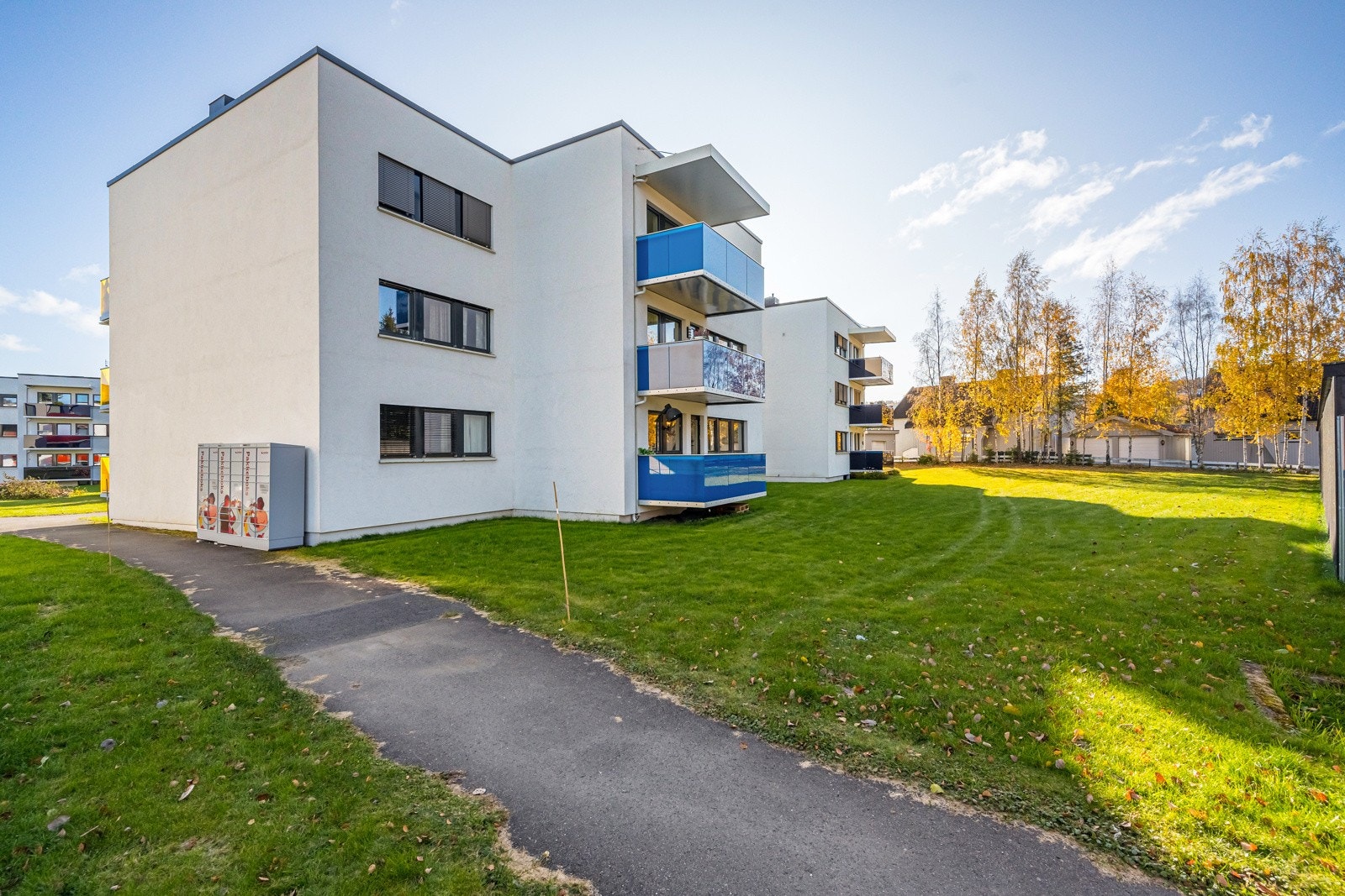 Felles tomt for borettslaget som er pent opparbeidet med plen, diverse beplantning og asfalterte internveger. Galleribilde