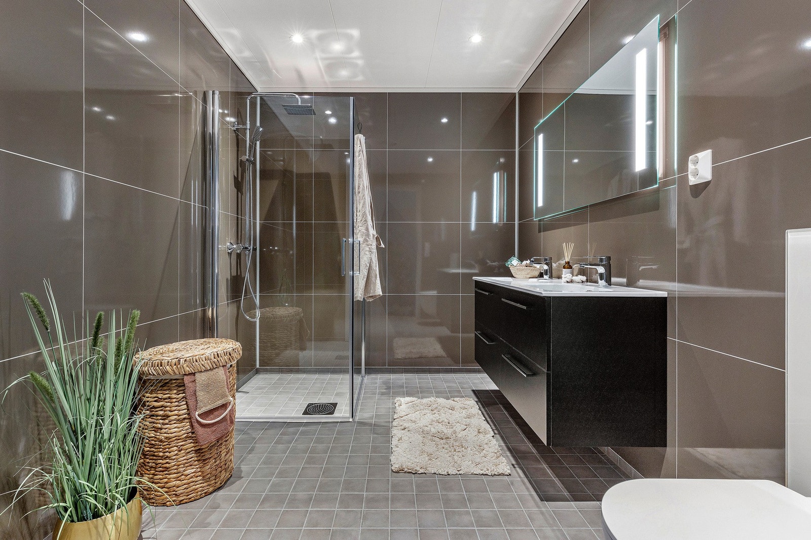 Baderommet har flislagt gulv (gulvvarme) og plater på veggene. I tillegg til baderom har boligen gjestetoalett samt eget vaskerom. Galleribilde