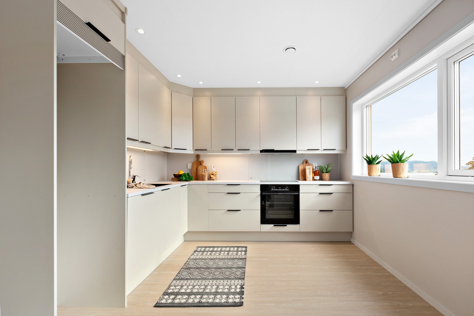 Kvalitetskjøkken fra Sigdal i stilren utførelse med høyskap samt downlights i tak. Galleribilde