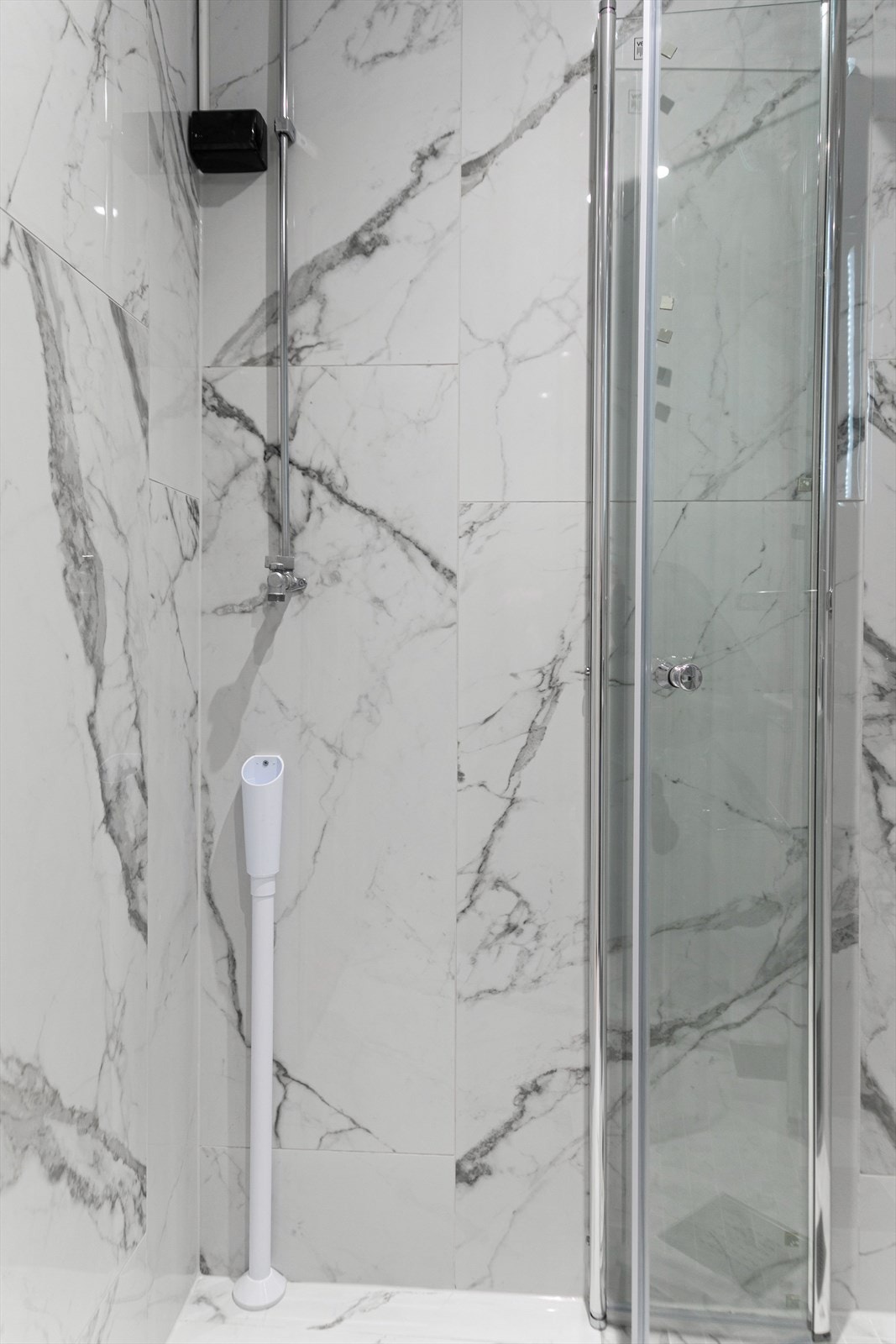 Videre er det et dusjhjørne med innfellbare dører i glass Galleribilde