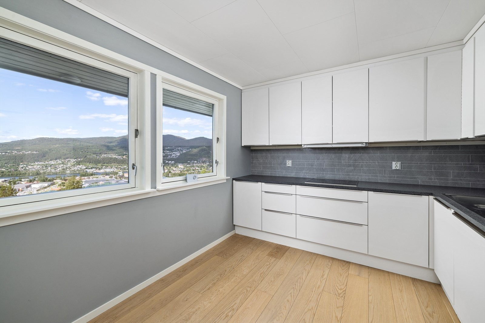 Kjøkkenet har innredning med glatte fronter. Benkeplaten er av laminat Galleribilde