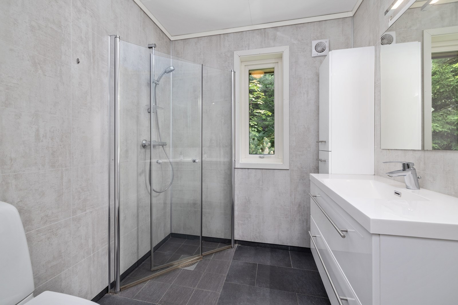 Badet har innredning med nedfelt servant, toalett og dusjvegger/hjørne. Galleribilde