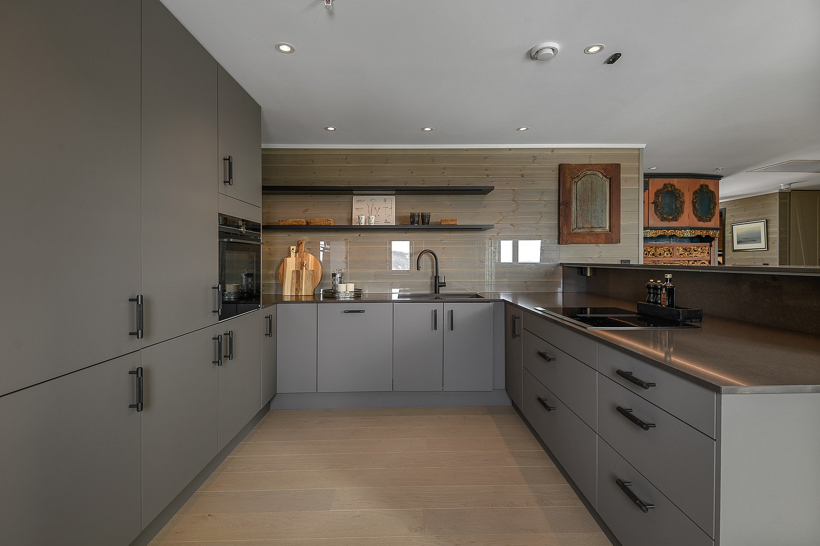 Kjøkkenet har en lekker innredning med glatte fronter og benkeplate i stein. Koketopp med integrert vifte fra Siemens. Galleribilde