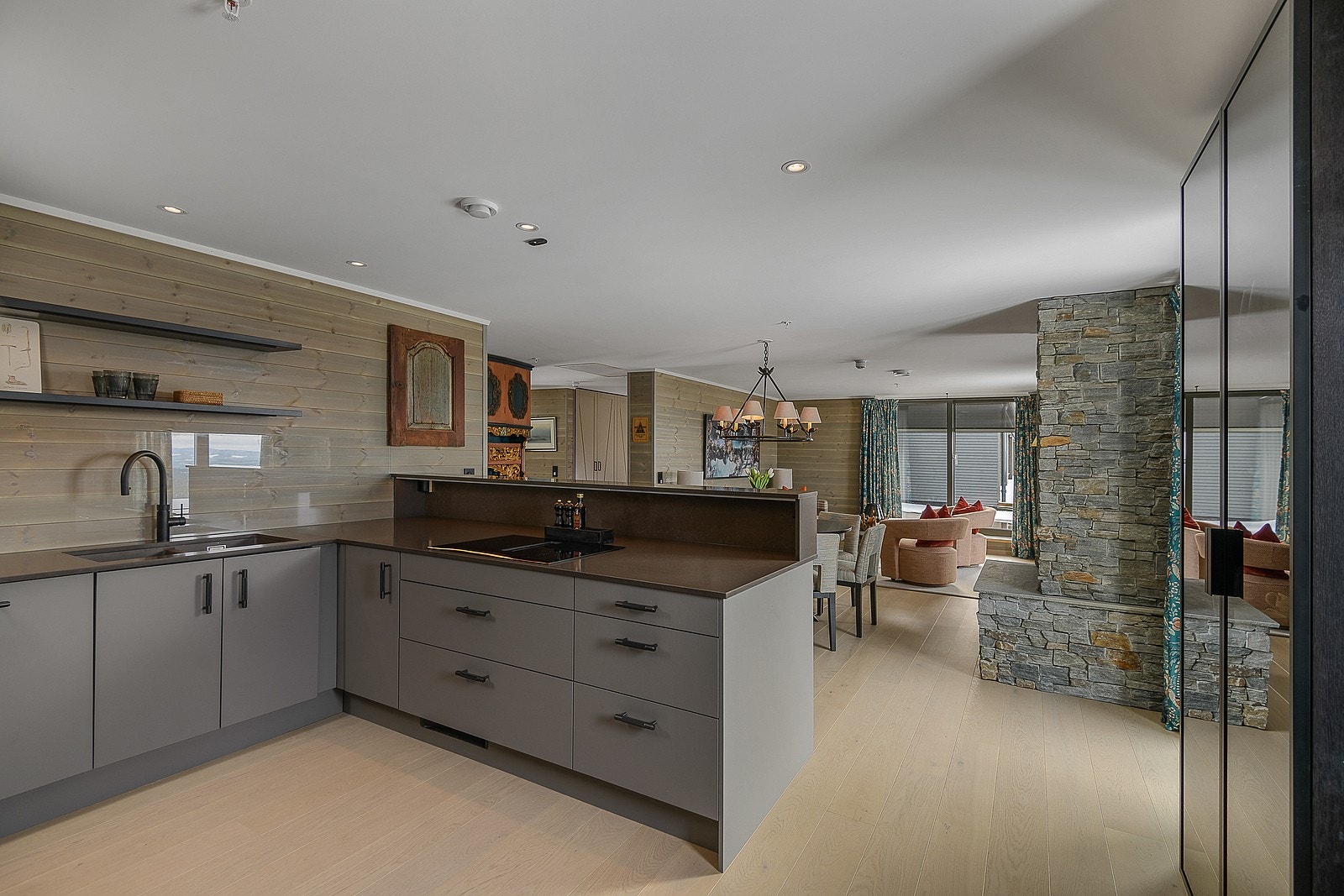 Kjøkkenet har en åpen løsning mot stuen med en forhøyet benk i forkant for servering og til fin skjerming for innsyn på kjøkkenet. Galleribilde