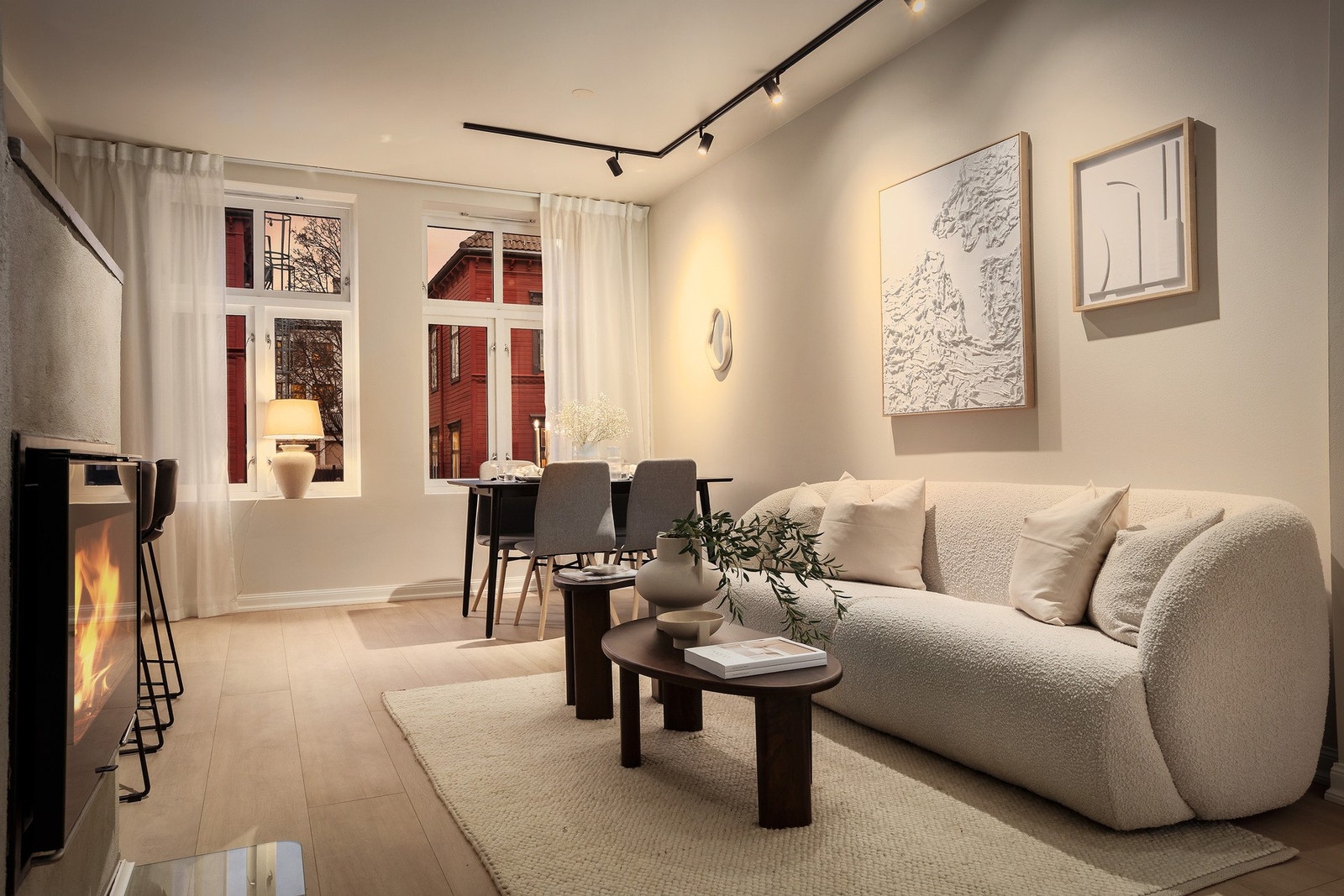 Lyse og lette gardiner fra tak til gulv går igjen i leiligheten og gir en elegant look i tillegg til de brede vinduskarmene og store gulvlister Galleribilde