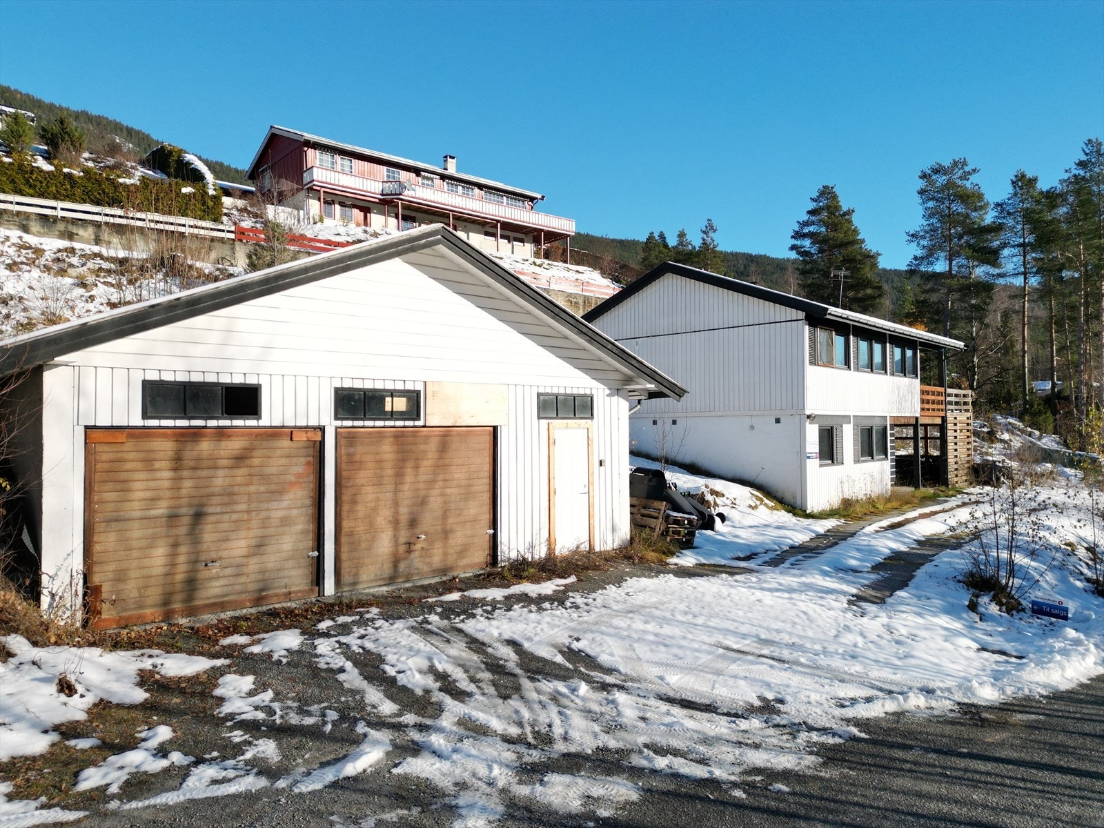 Boligen har enkel adkomst fra en blindveg med parkeringsplass rett utenfor og i den store garasjen. Galleribilde