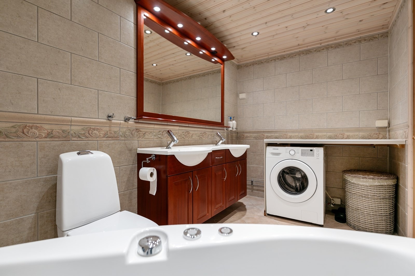 Boligen har to bad - Bad 1 er innredet med dobbel servant, klosett, badekar og opplegg for vaskemaskin/tørketrommel med tilhørende benkeplass. Galleribilde