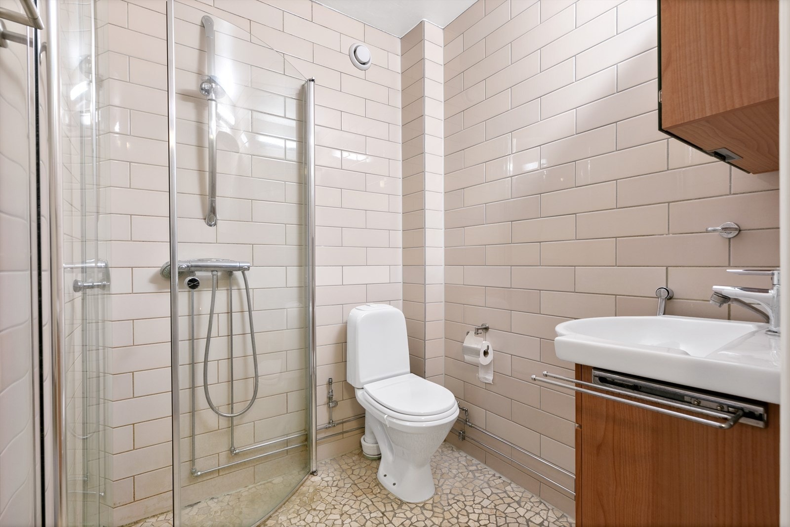 Bad 2 er innredet med servant med skuffeinnredning, klosett og dusjhjørne. Galleribilde