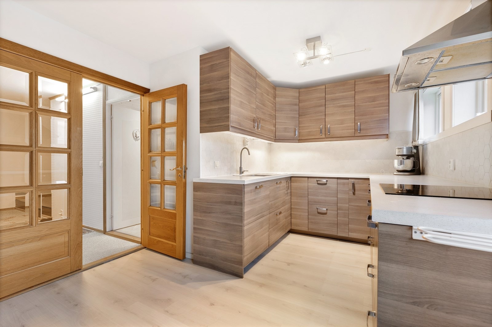 Den praktiske utformingen fordelt på tre sider, sørger for rikelig med oppbevaringsmuligheter samt god og luftig benkeplass for matlaging. Galleribilde