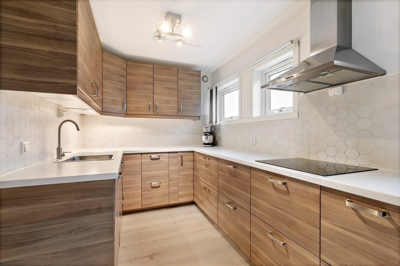 Lekkert kjøkken med mørke fronter og hvite veggfliser gir kjøkkenet et svært moderne utrykk. Galleribilde