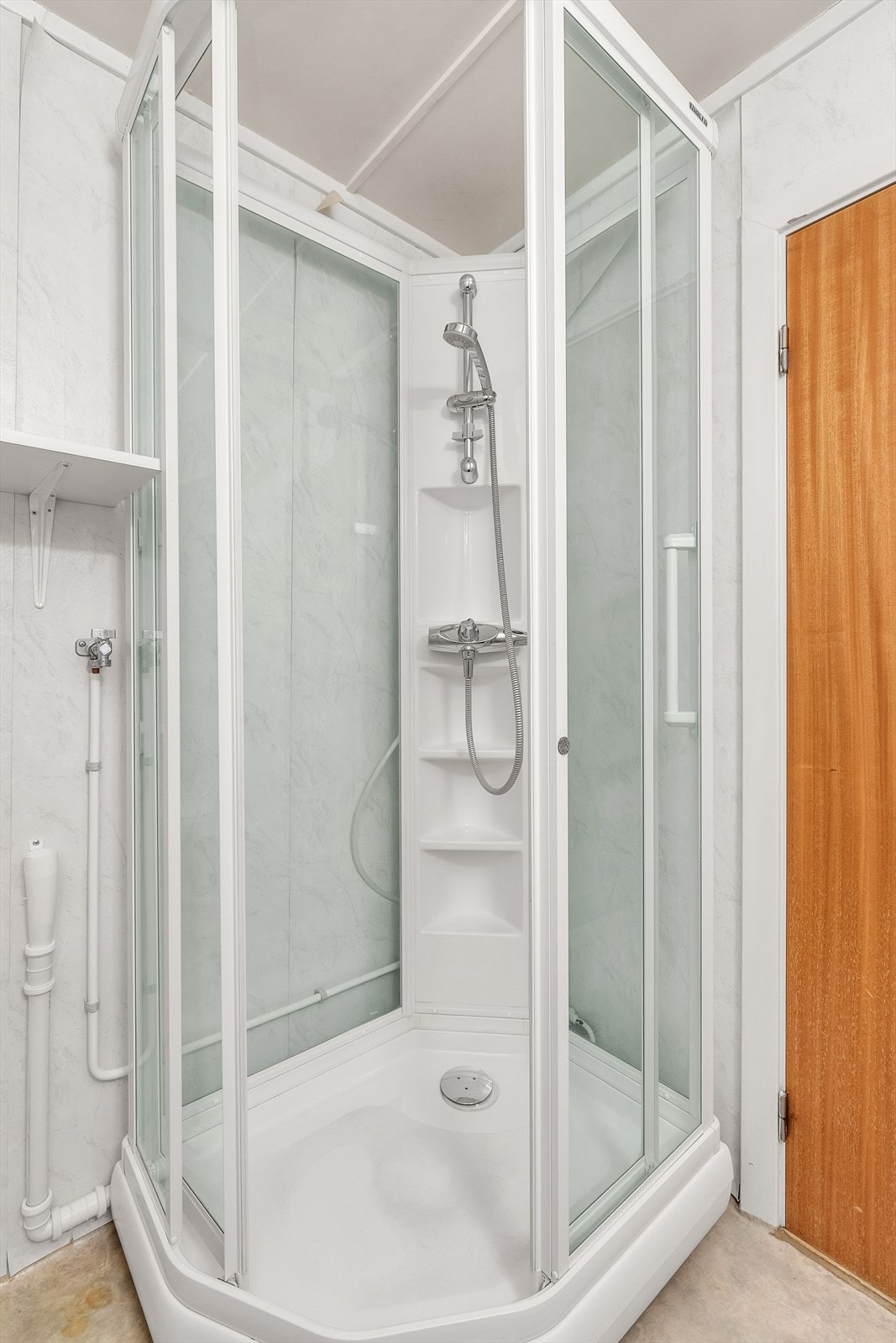 Videre er badet utstyrt med dusjkabinett og opplegg for vaskemaskin. Borettslaget har også felles vaskekjeller. Galleribilde