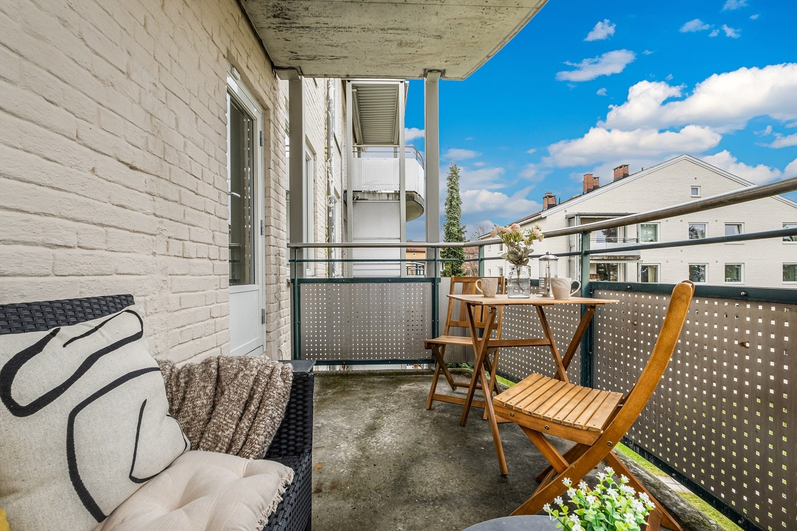 Balkongen vender mot borettslagets pent opparbeidede uteareal med plen og beplantning Galleribilde