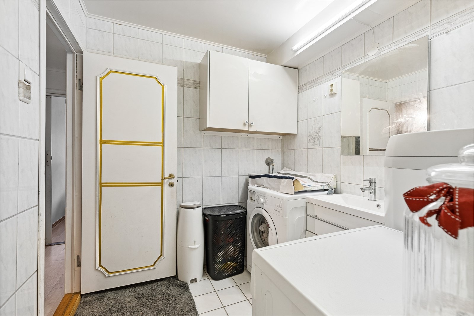 Stort og lyst bad med tidløse fliser. Det er opplegg for vaskemaskin og tørketrommel. Galleribilde