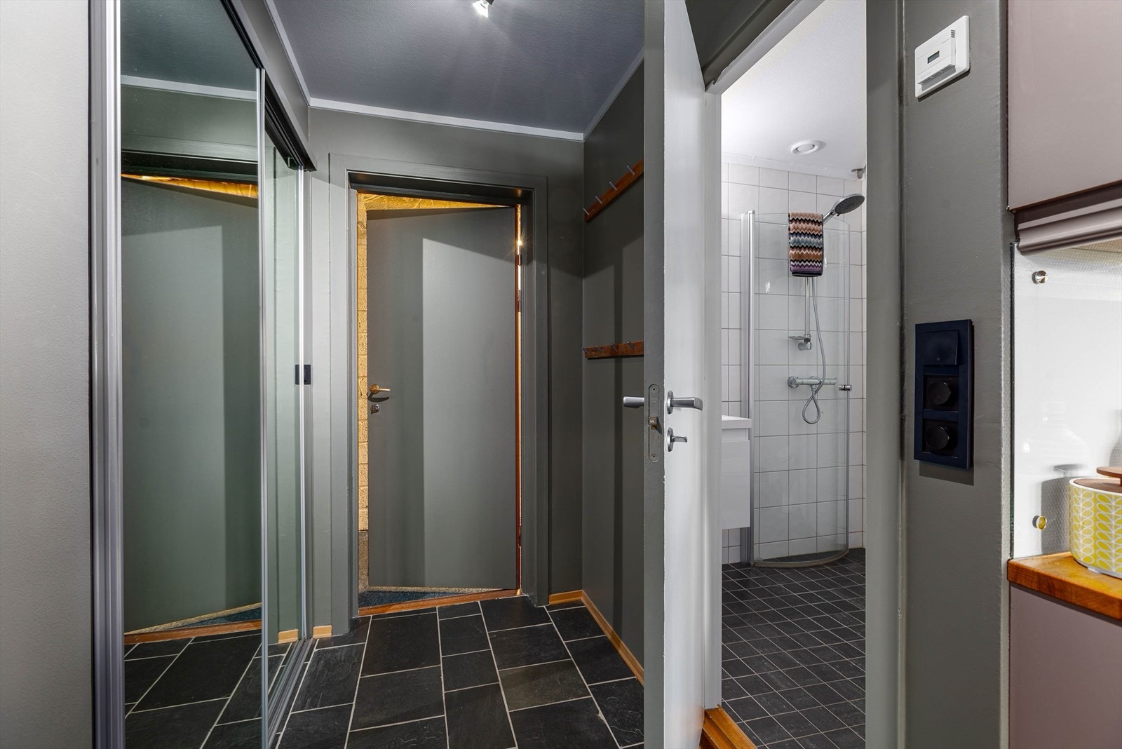 Flislagt gang med skyvedørsgarderobe i speil. Galleribilde