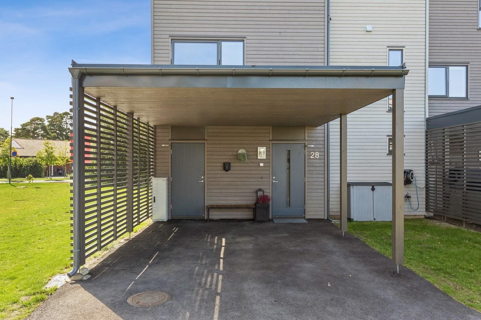 Inngangsparti med carport. Her finnes i tillegg en utvendig bod samt el-bil lader Galleribilde