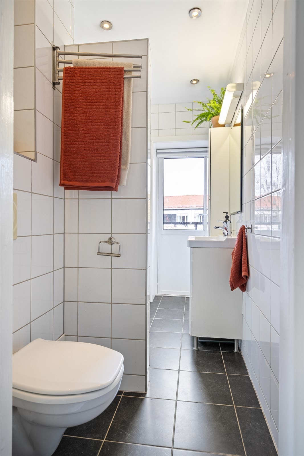 Badet er innredet med veggmonterte dusjvegger, dusj direkte på gulv med termostat batteri, veggmontert klosett, servant med skapinnredning, speilskap og plass for vaskemaskin. Elektrisk baderomsvifte. Galleribilde