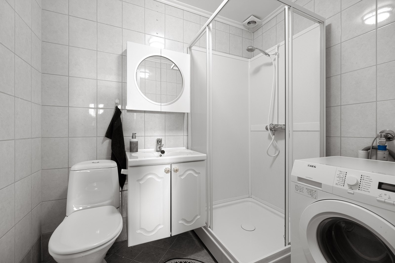 Flislagt bad med opplegg også for vaskemaskin. Det er elektriske varmekabler i gulvet Galleribilde