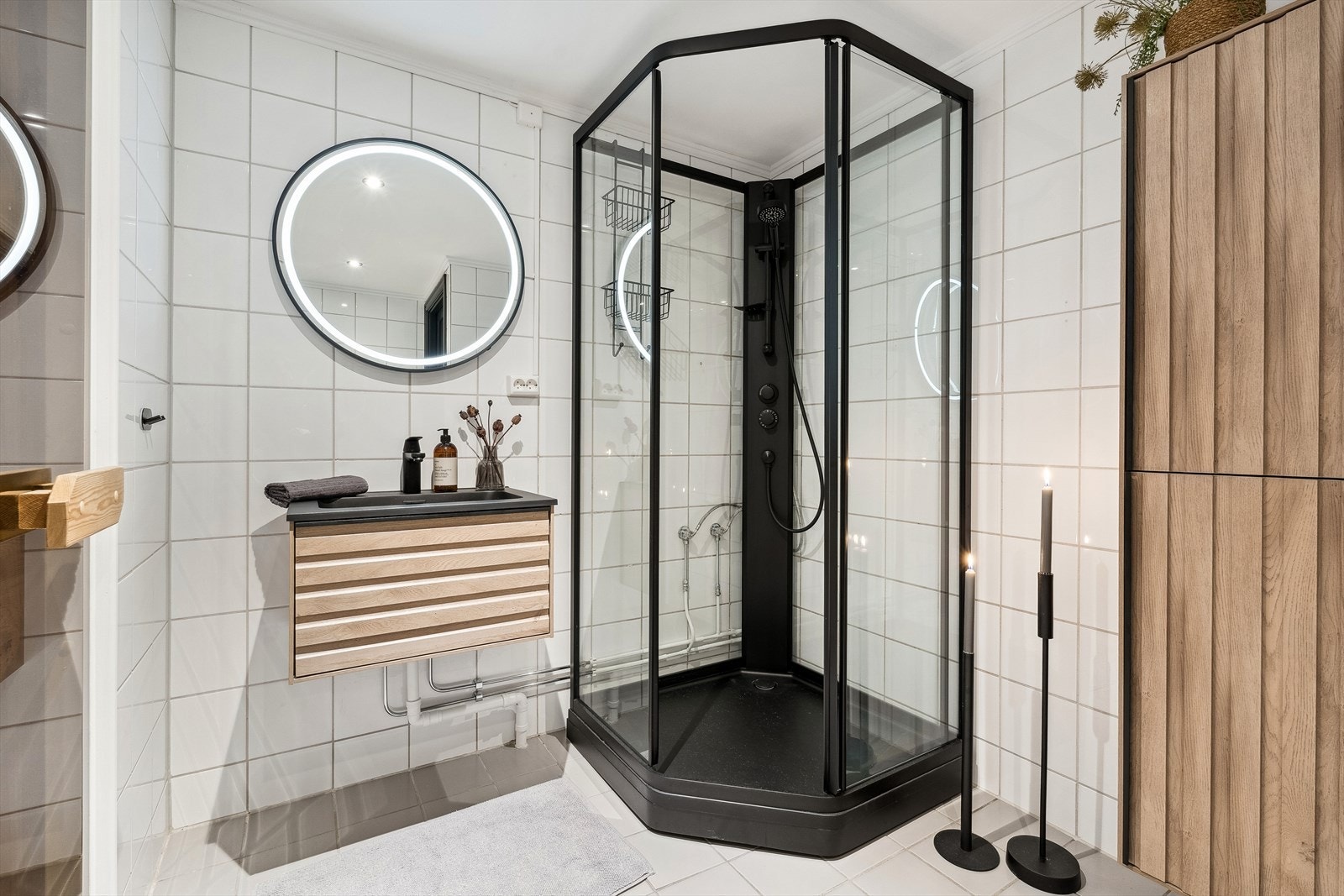 Bad 2 med flislagte overflater og varmekabler i gulv, moderne innredning med nedfelt servant, vegghengt skap, toalett og dusjkabinett. Galleribilde