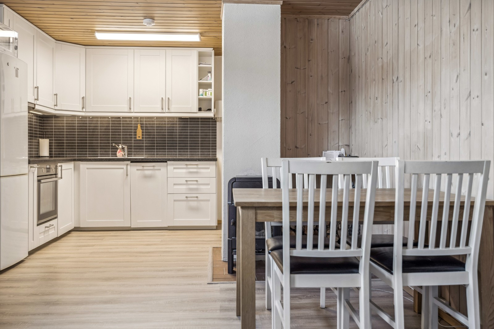 Kjøkken i underetasje med slette profilerte fronter og integrert koketopp/komfyr.
