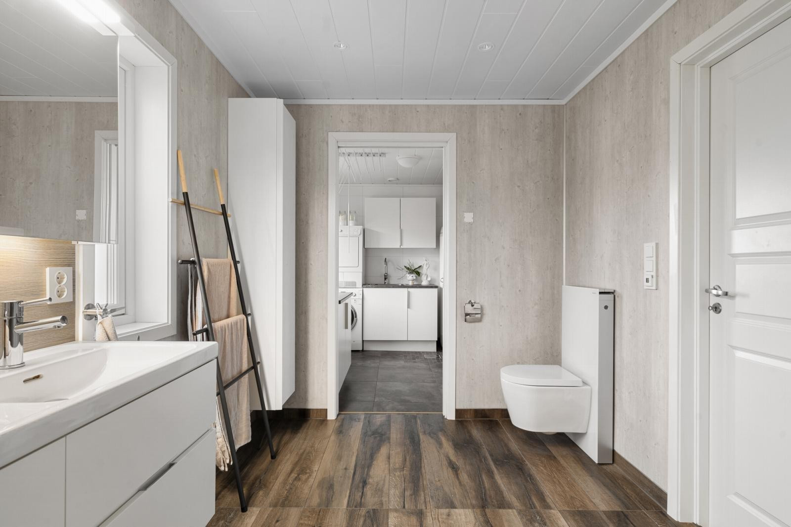 Hovedbadet/vaskerommet i 1. etasje framstår stort og er utstyrt med gulvvarme, dusjhjørne, vegghengt wc og opplegg for vaskemaskin.