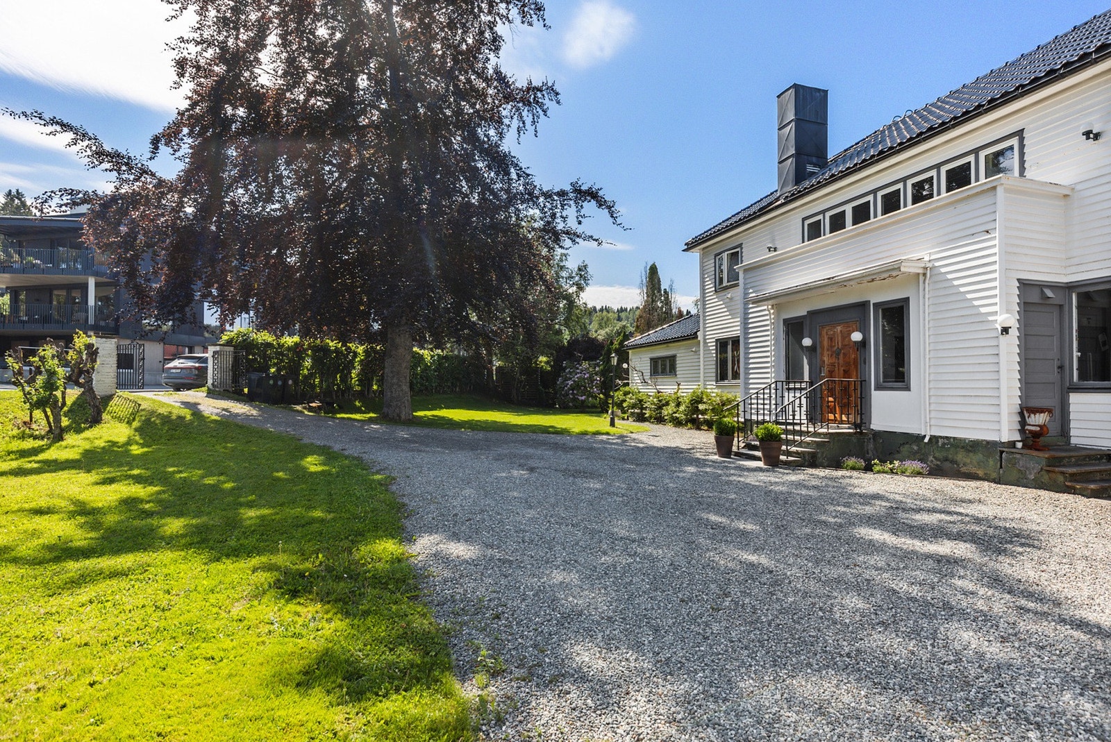 Tomten skiller seg ut med en svært romslig gårdsplass. Her er det flere oppstillingsplasser i tillegg til dobbeltgarasje med elbil-lader. Galleribilde
