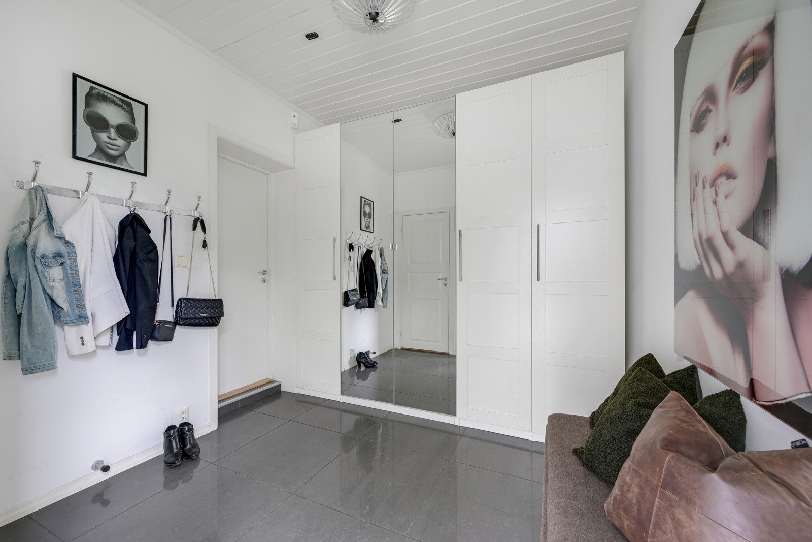 Stor flislagt hall med garderobeskap og oppheng. Galleribilde