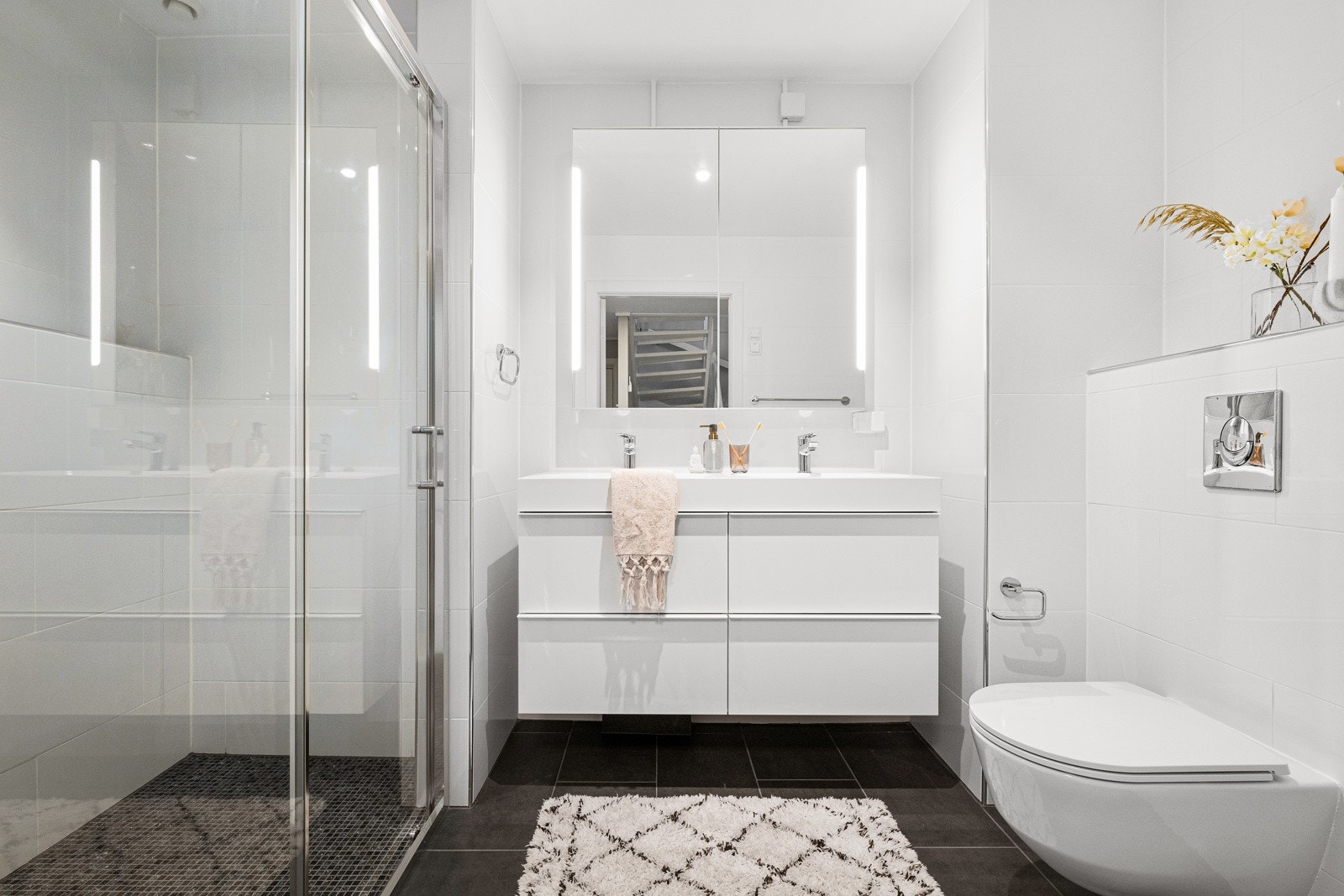 Badet er pusset opp i 2023 og her er sorte gulvfliser kombinert med hvite veggfliser for en fin kontrast. Galleribilde