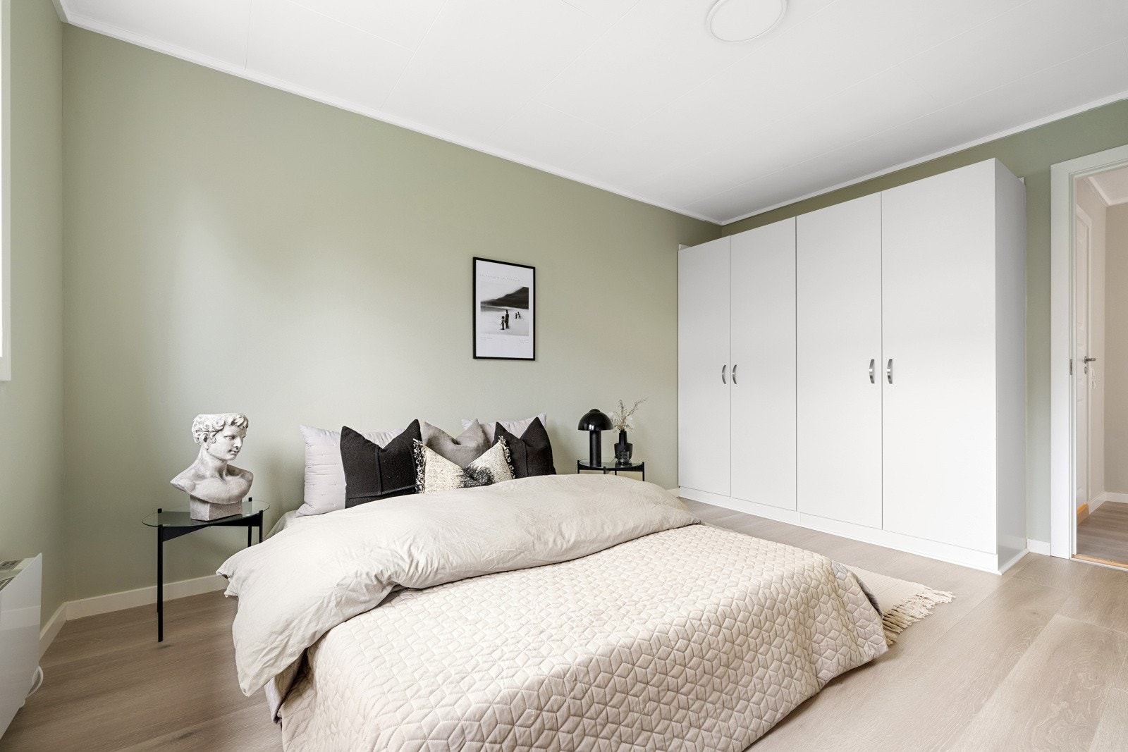 Veggene er malt i en dus og tidsriktig grønnfarge, noe som bidrar til en behagelig atmosfære. Galleribilde