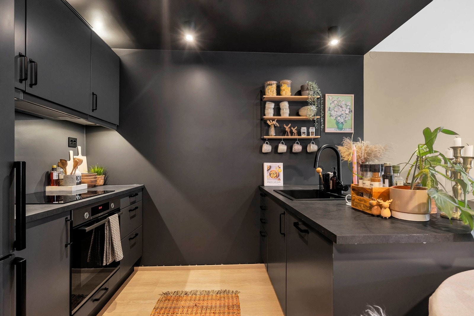 Lekkert kjøkken med sort innredning og integrerte hvitevarer Galleribilde