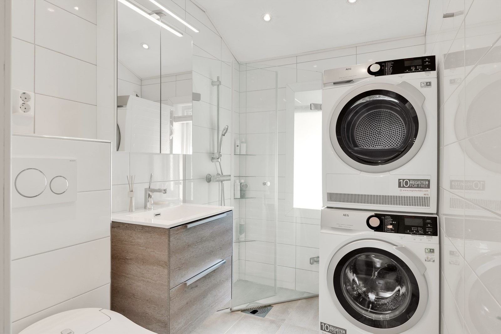 Stilrent baderom med flislagt gulv med elektriske varmekabler og flislagte vegger. Galleribilde