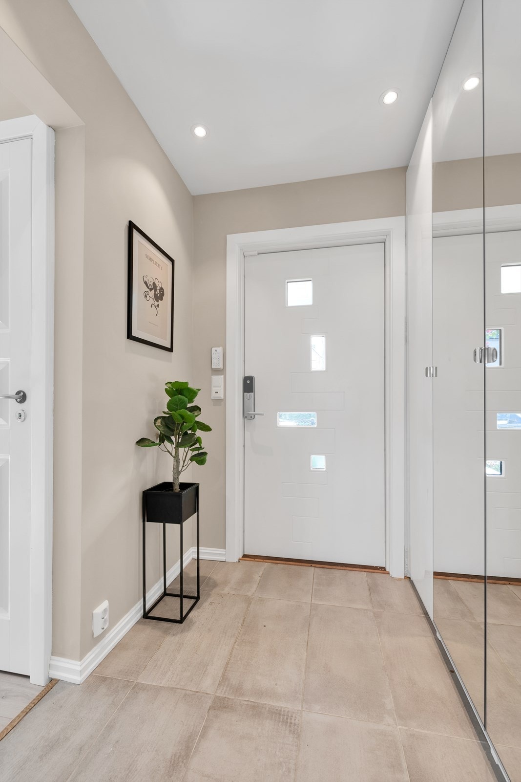 Lys og åpen entré med et stort garderobeskap med speildører. Her er det god plass til oppbevaring av sko og klær. Galleribilde