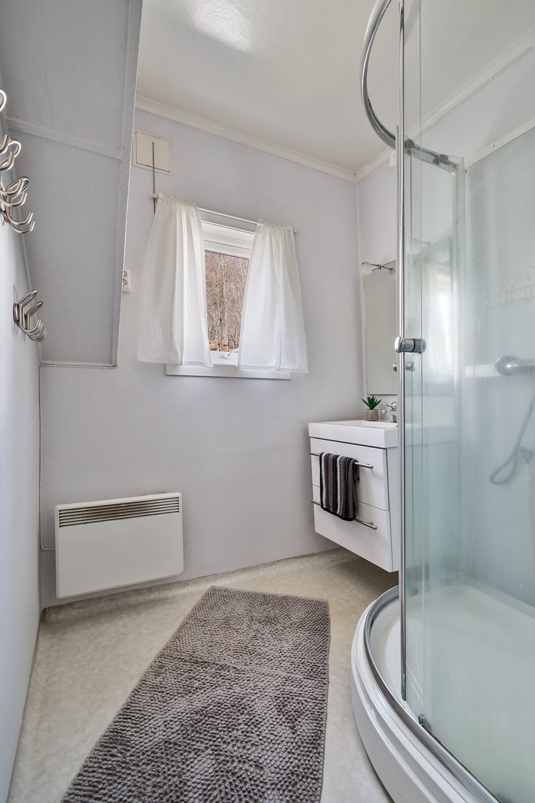 Badet i 2.etg. er innredet med dusjkabinett og enkel servant. Galleribilde