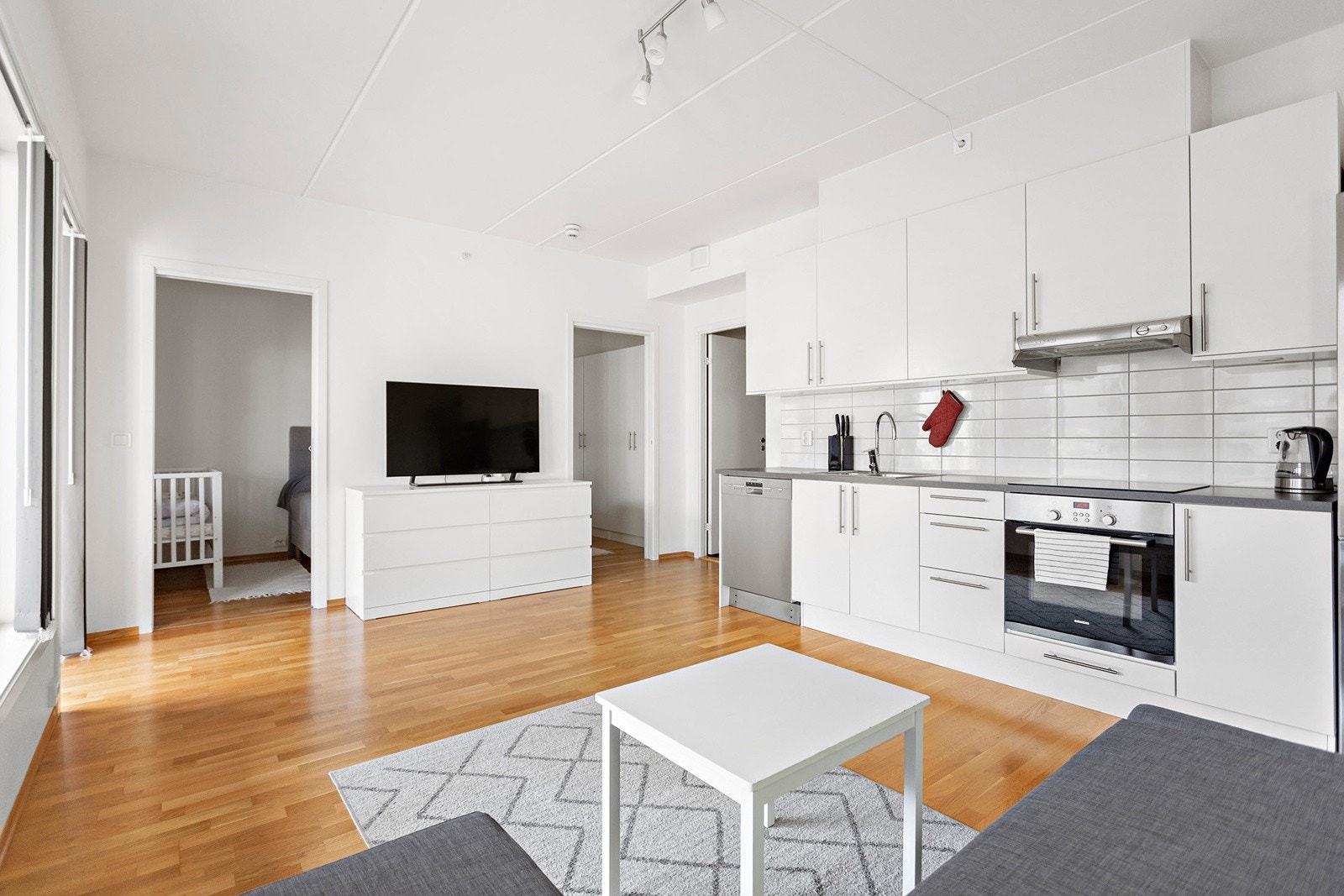 Kjøkkenet består av hvite slette fronter og laminat benkeplate. Galleribilde