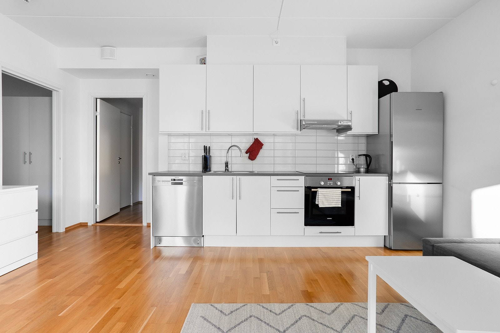 Kjøkkenet består av hvite slette fronter og laminat benkeplate. Videre er det integrert komfyr og platetopp. Galleribilde