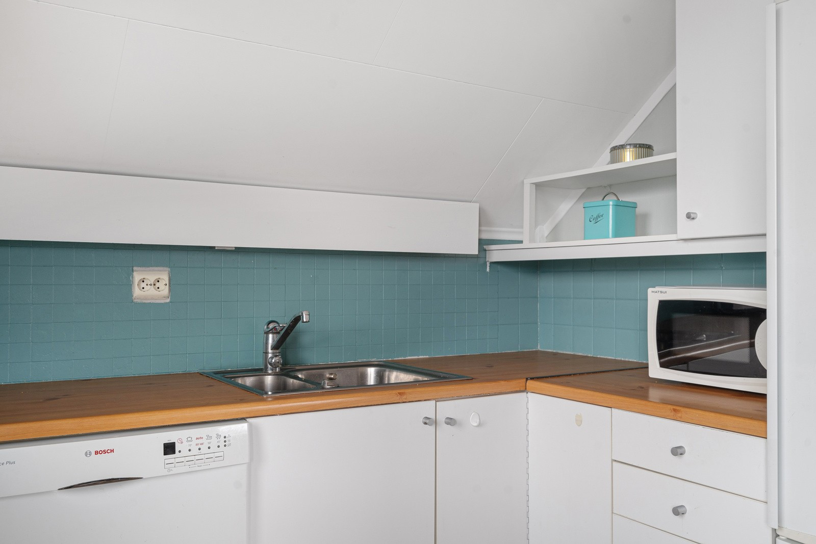 Glatte fronter og benkeplate i laminat, plass til frittstående kjøl/frys, komfyr og oppvaskmaskin.