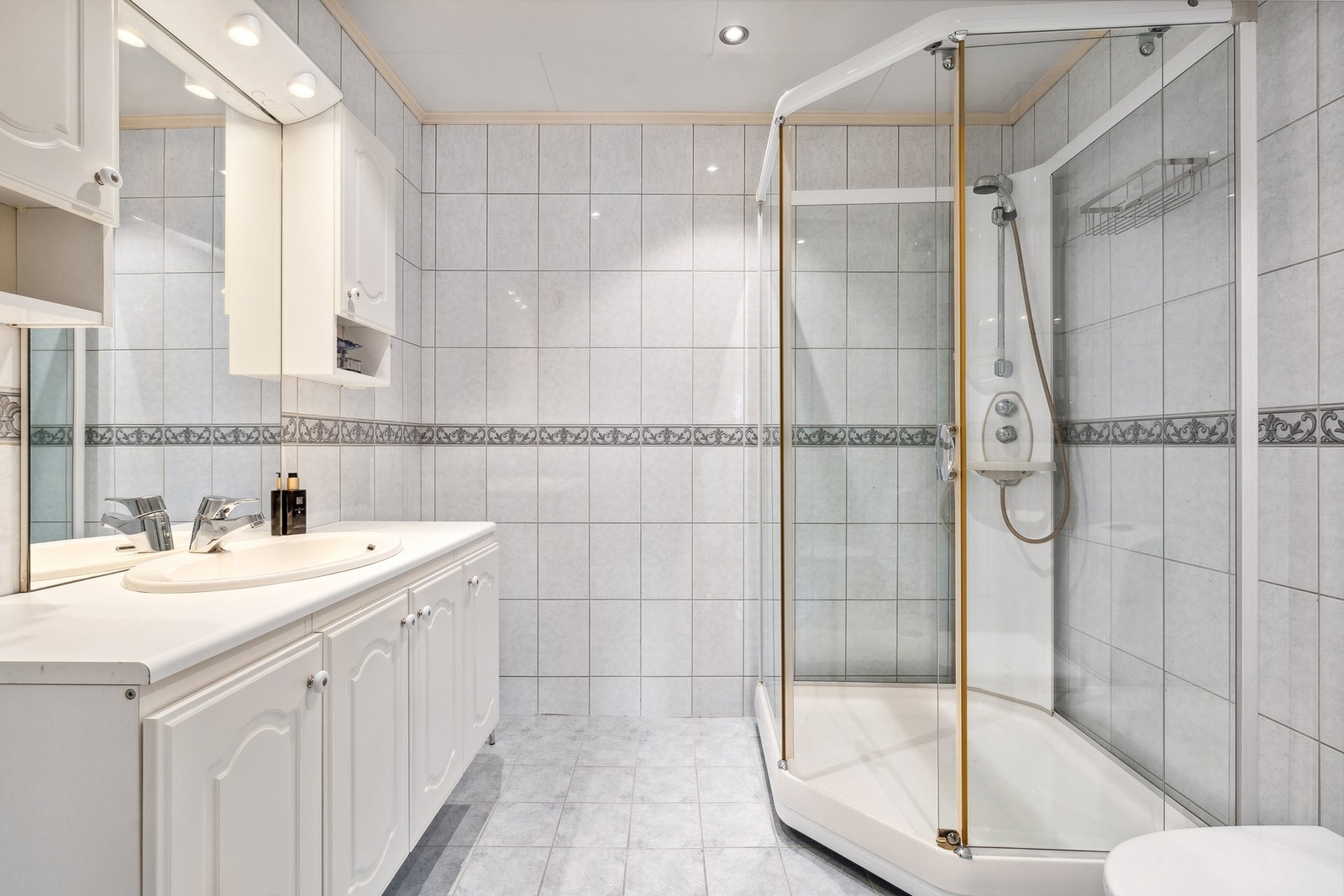 Badet har innredning med nedfelt servant, speil med lys, frittstående toalett og dusjkabinett. Galleribilde