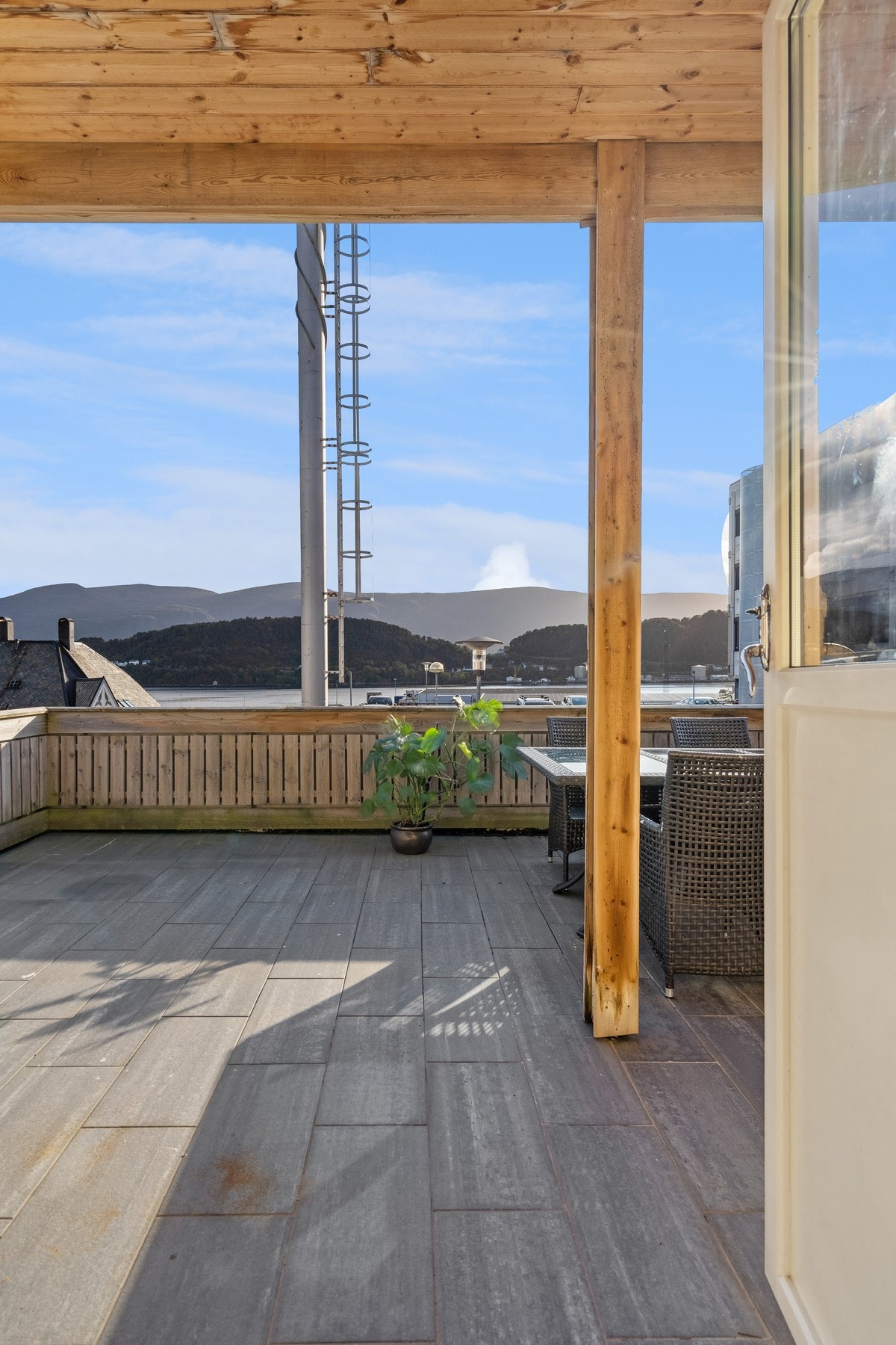 Terrassen er oppbygget av flis på dekke og rekkverk/levegg i malt tre. Galleribilde