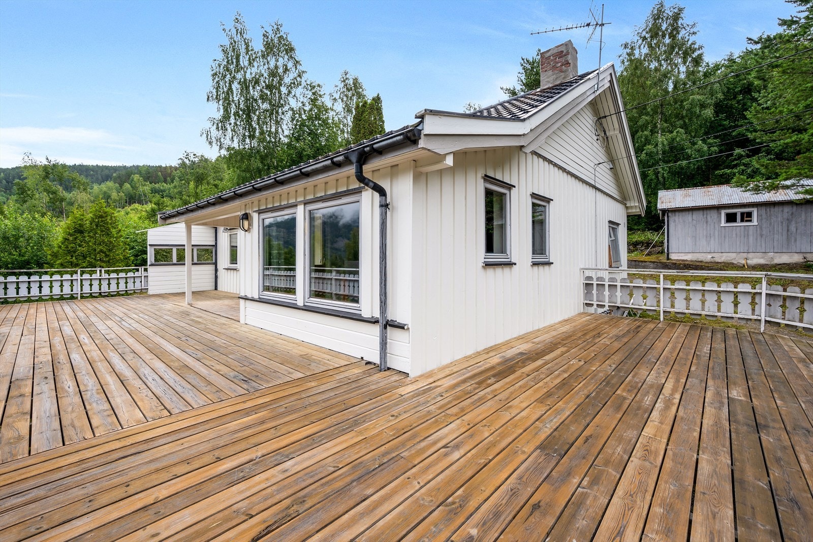 Terrassen omkranser store deler av boligens fremside. Galleribilde