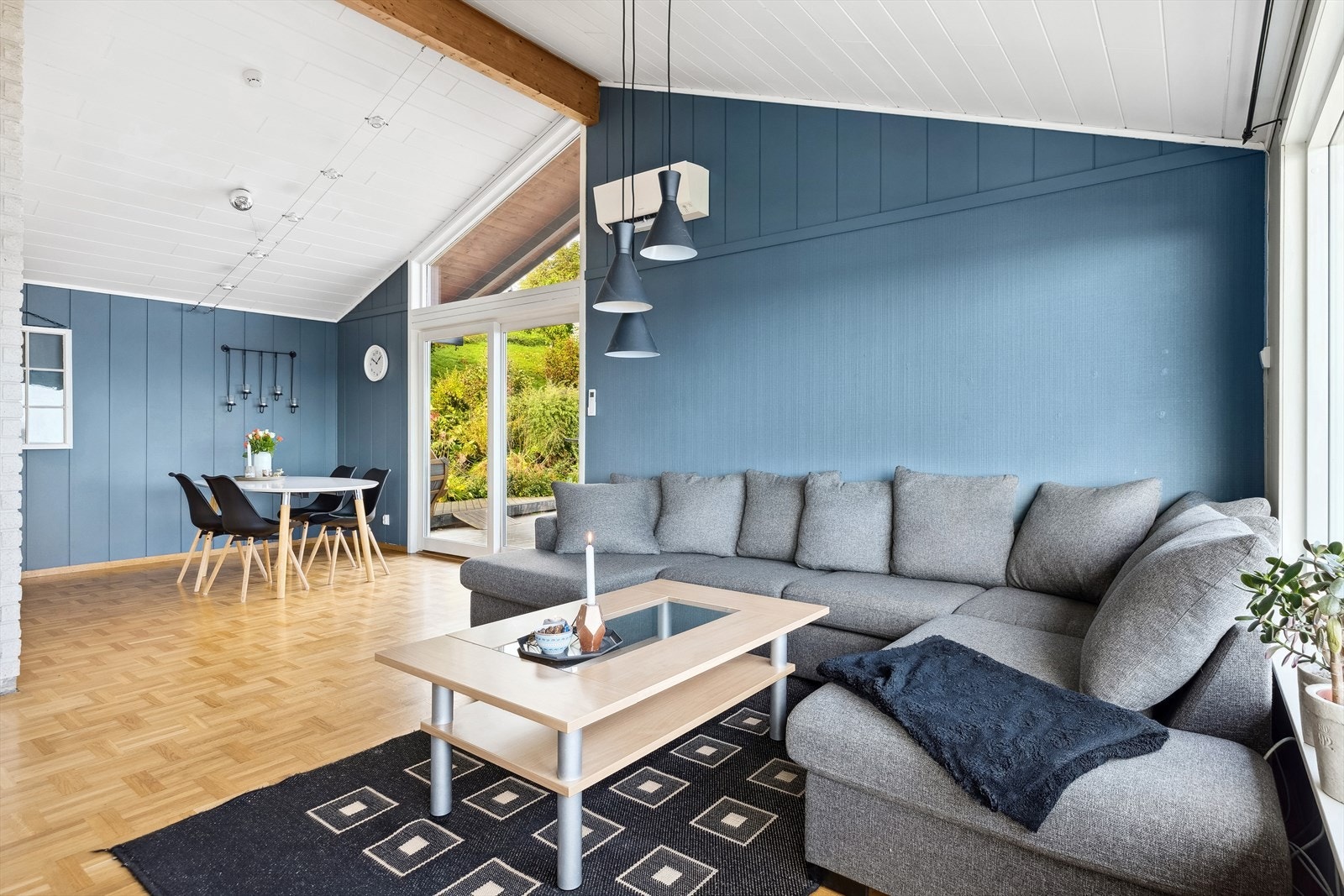 Stuen har parkettgulv, malt veggpanel og skråtak som skaper et ekstra luftig preg. Galleribilde