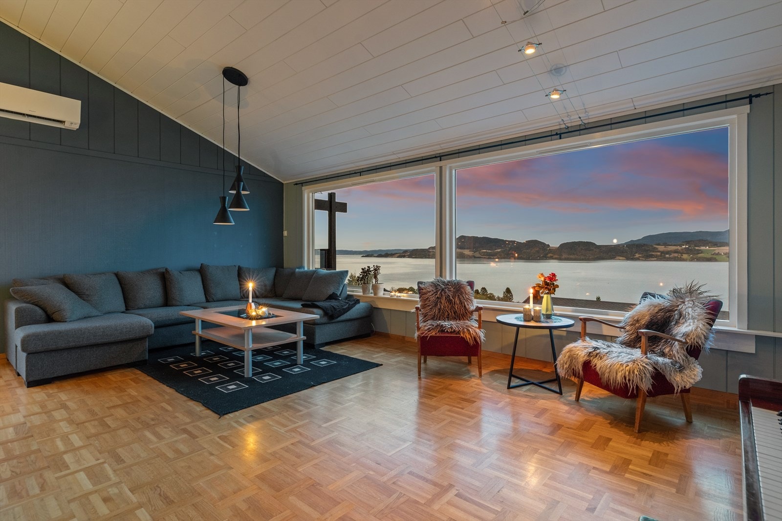 Rause vindusflater fyller stuen med naturlig lys og trekker nærmest sjø og landskap inn i rommet. Galleribilde