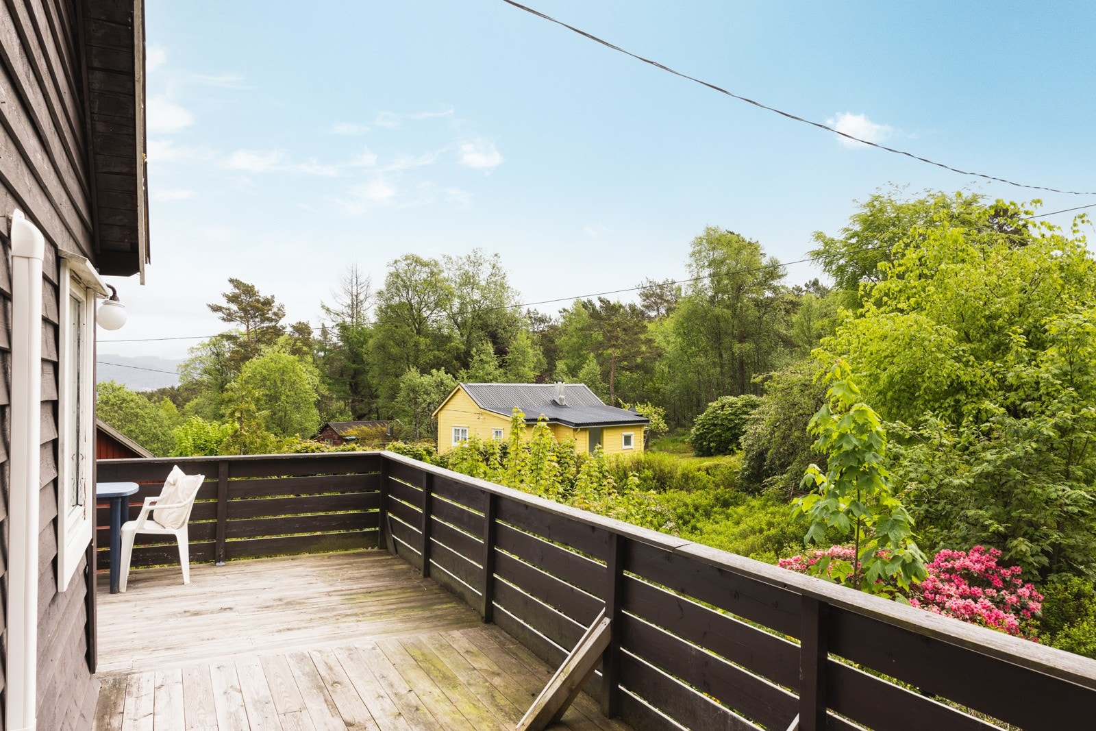 Stor altan som går delvis rundt huset. Galleribilde