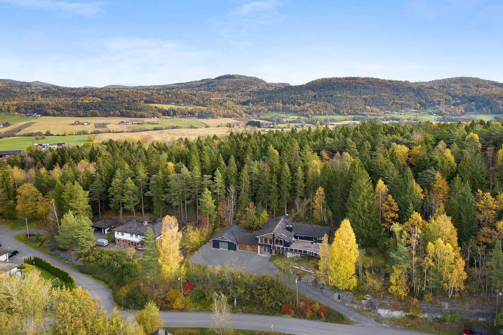 Oversiktsbilde. Landlige omgivelser helt i skogkanten. Galleribilde