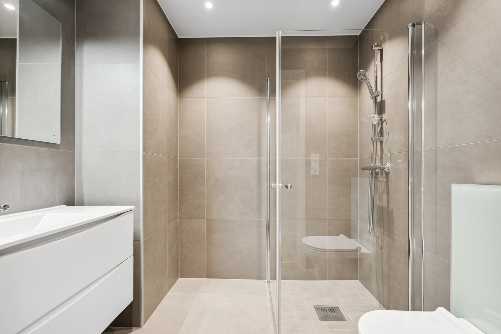 Komplett flislagt bad med varme i gulv. Store fliser i smakfull farge. I tillegg til hovedbad så er det ekstra wc med vask i boligen Galleribilde