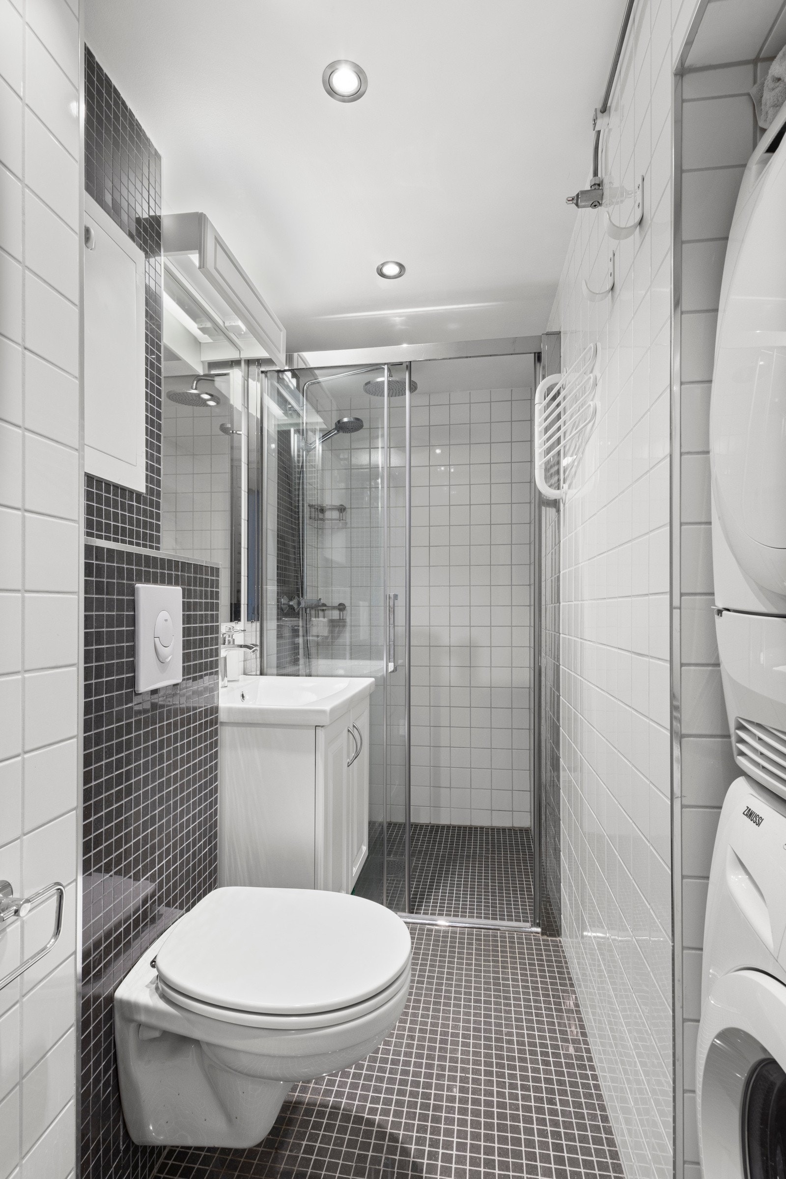 Innredning på bad består av vegghengt wc, dusjplass med dusjvegg med skyvedør, heldekkende servant med ettgreps blandebatteri i innredning og opplegg for vaskemaskin Galleribilde