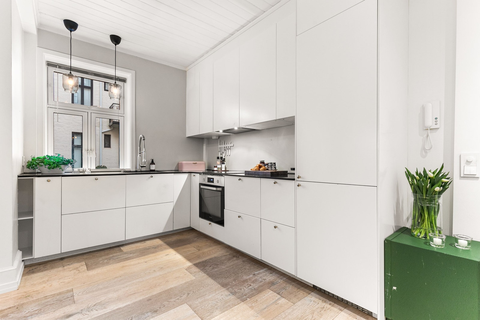 Moderne og tidløst kjøkken fra 2014 med hvite fronter. Praktisk innredet i en L-from langs to vegger med god oppbevaring- og arbeidsplass. Galleribilde