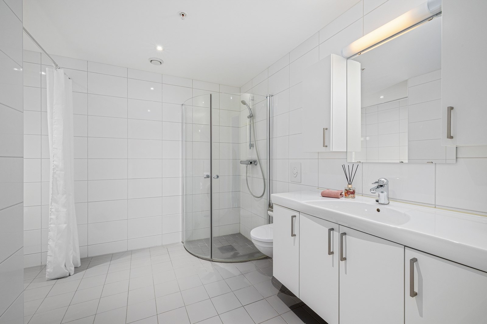 Delikat baderom med flis på gulv og vegger og tak i malte plater m/downlight. Galleribilde