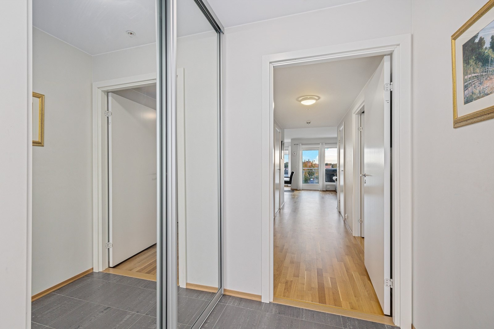 Lys og delikat entrè med skyvedørsgarderobe. Galleribilde
