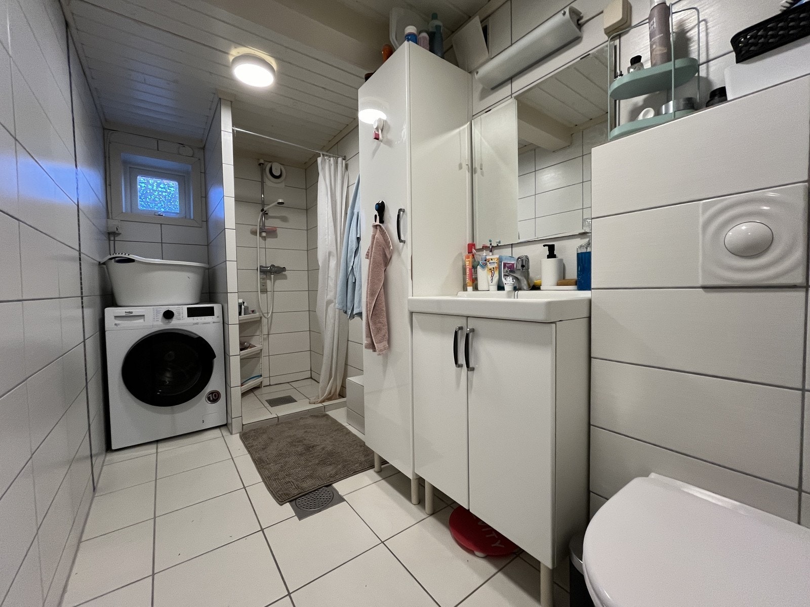 Pent flislagt bad med vegghengt wc, hjørnedusj og servant m/innredning Galleribilde