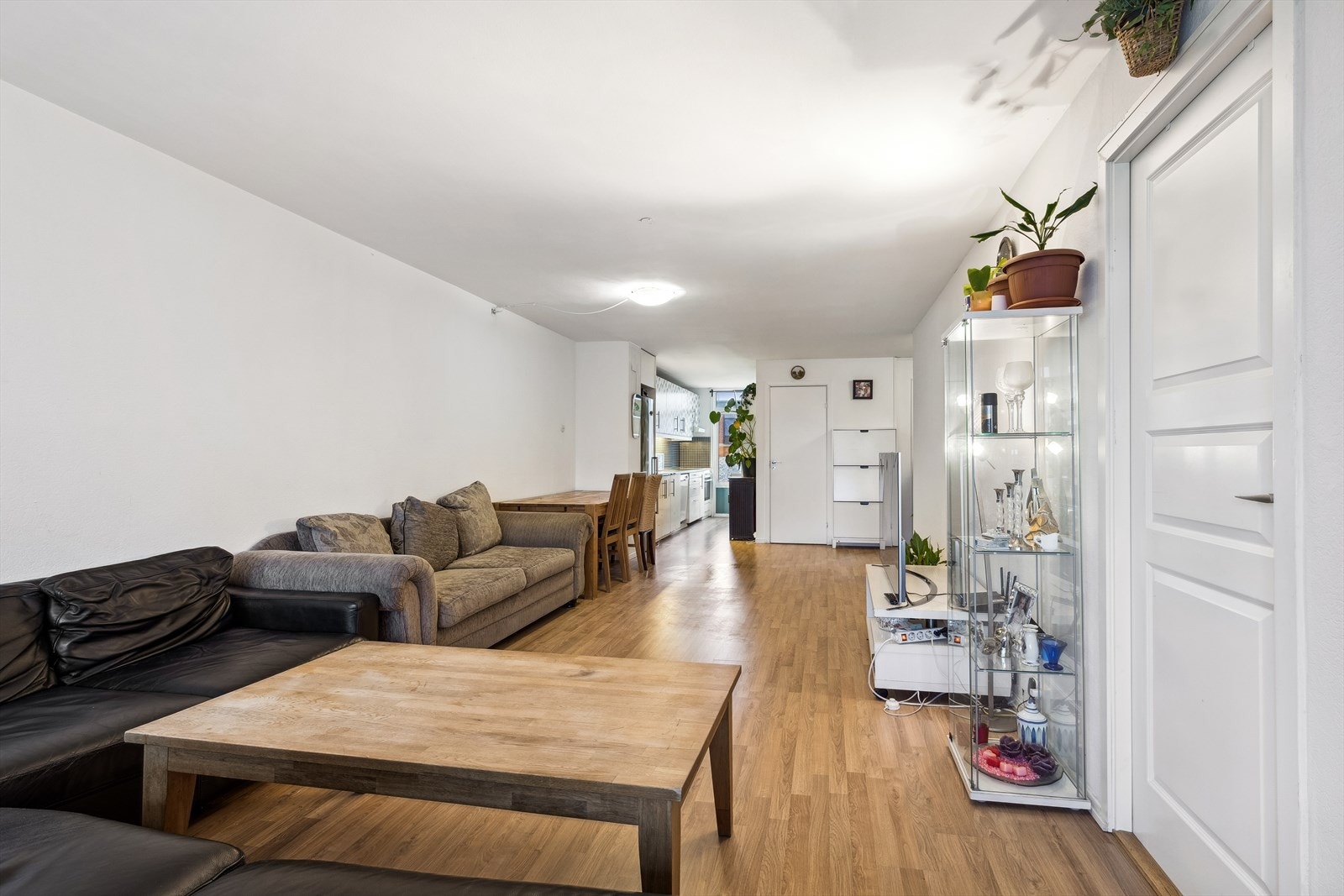 Den gjennomgående løsningen og de store vinduene gir stuen en lys og luftig atmosfære Galleribilde